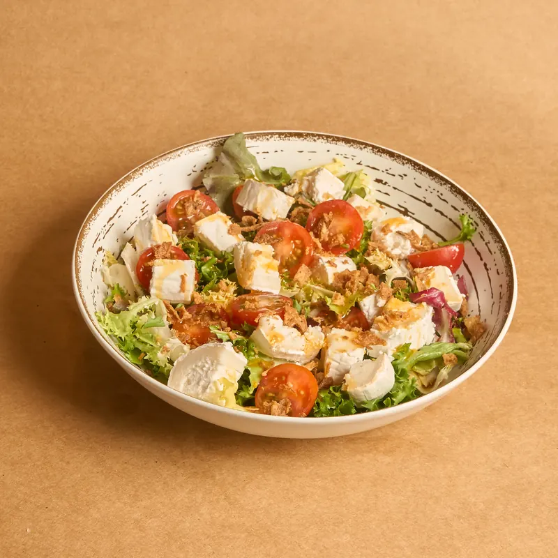 Ensalada de queso de cabra con tomate y hojas verdes Tronco Grill